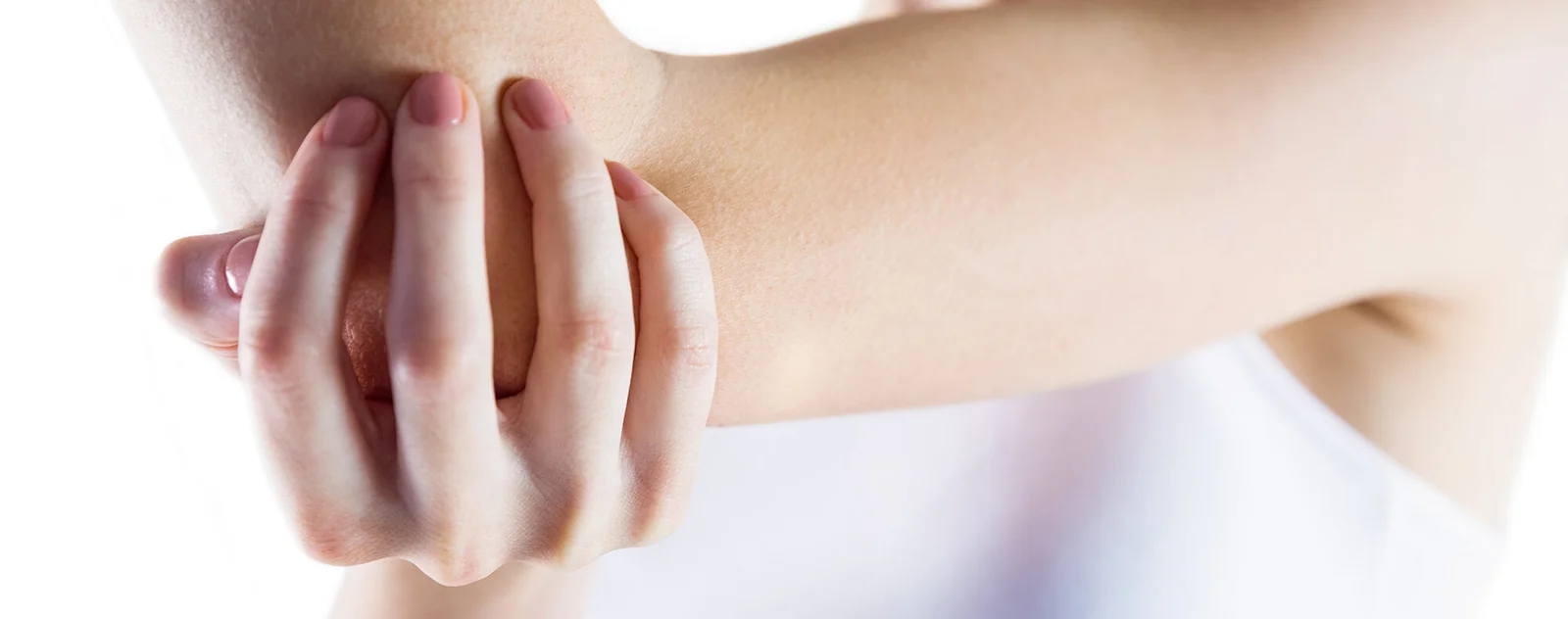 A person holding their bare elbow in pain, indicating discomfort or injury.