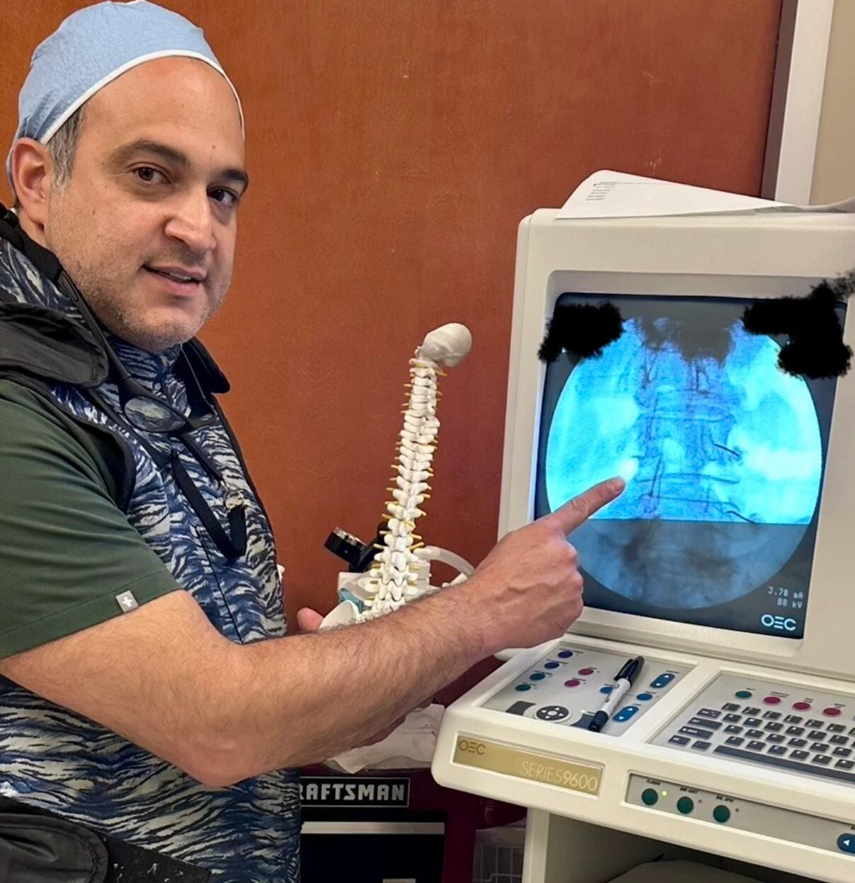 A doctor showing a spinal X-ray on an oscilloscope screen