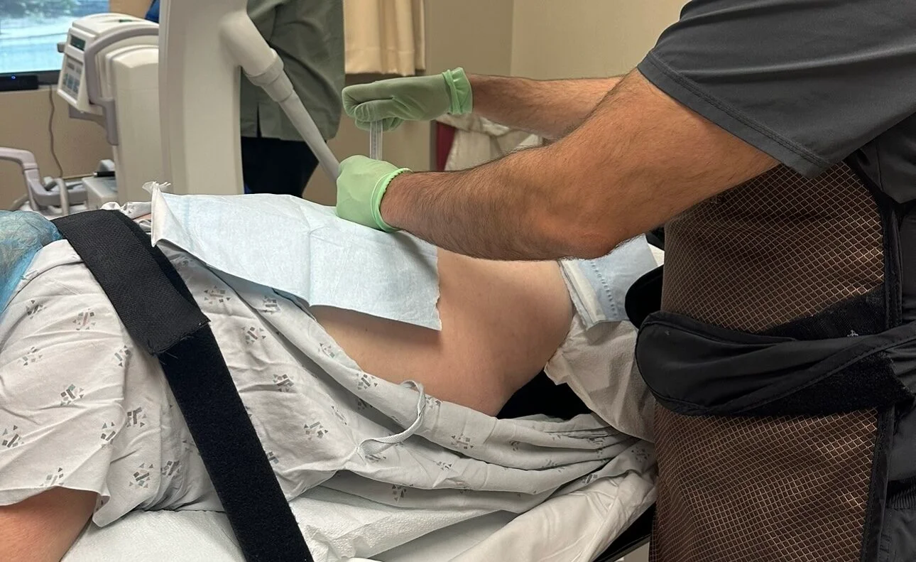 A doctor using a back pain therapy machine for a patient.