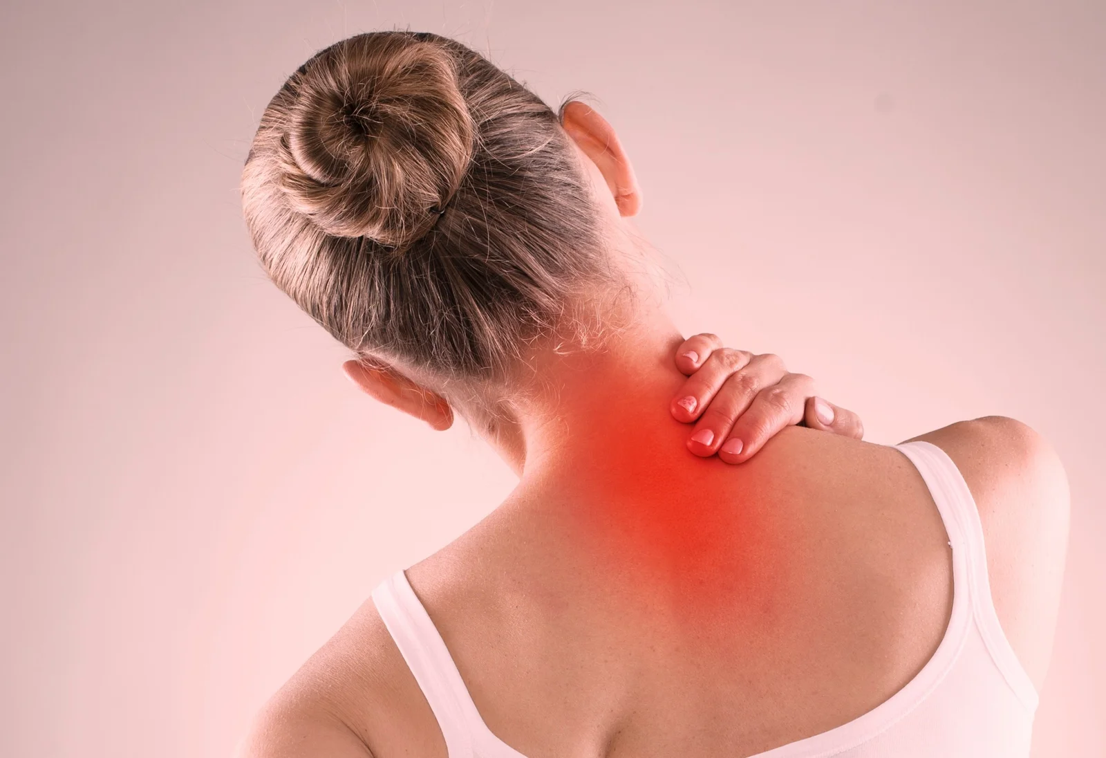 A girl holding her upper back in pain, indicating discomfort in the upper back area.