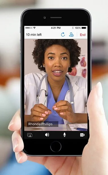 A female doctor appearing on a patient’s phone for an online consultation.