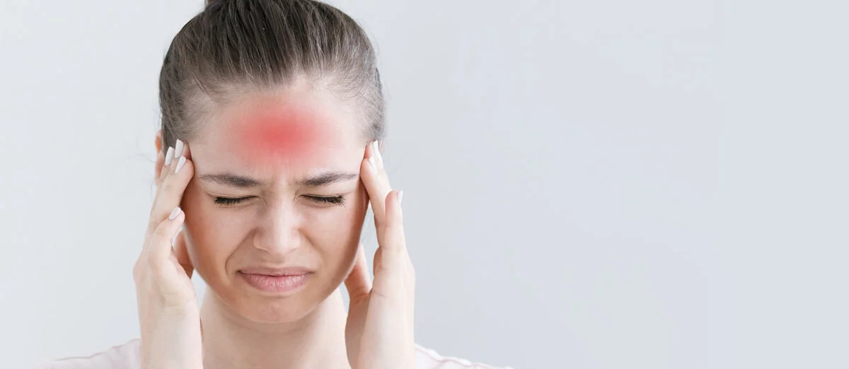 A black-and-white image of a girl’s head with red spots highlighting areas of headache pain.